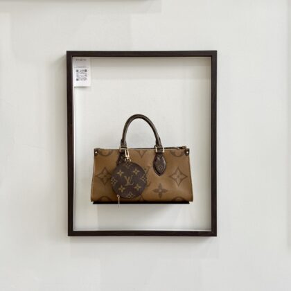 LV On The Go East West Monogram Reverse GHW with Cream Canvas Strap